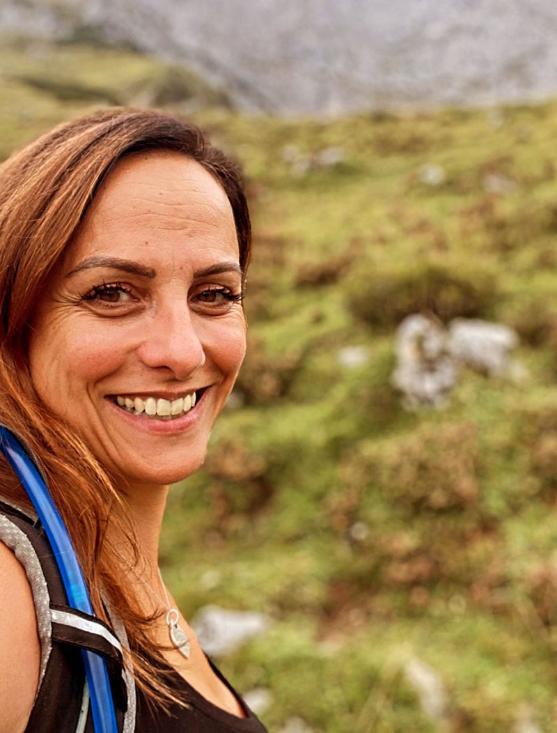 Tanja Dill lachend beim Wandern in den Bergen