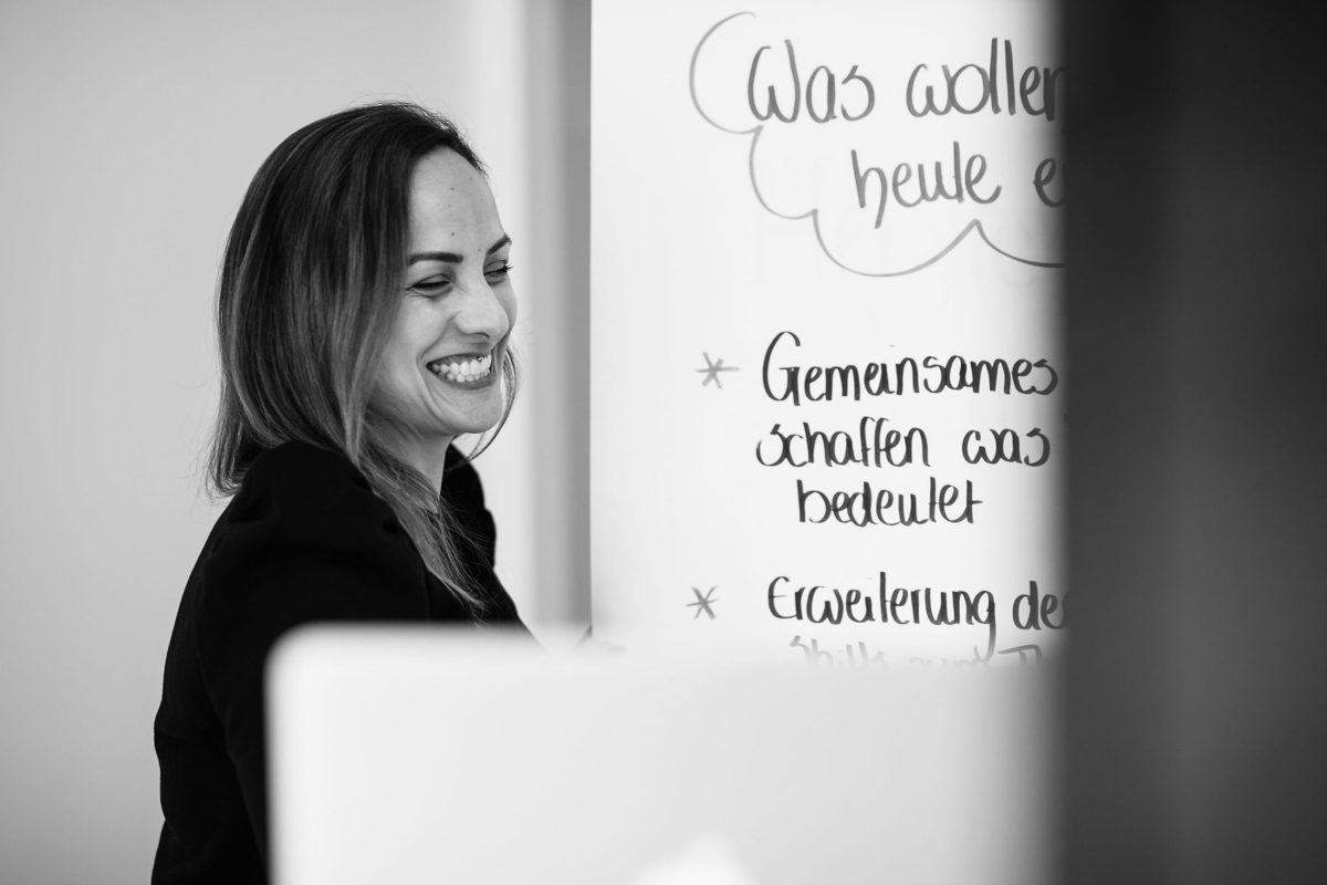 Tanja Dill lacht am Flipchart im Training
